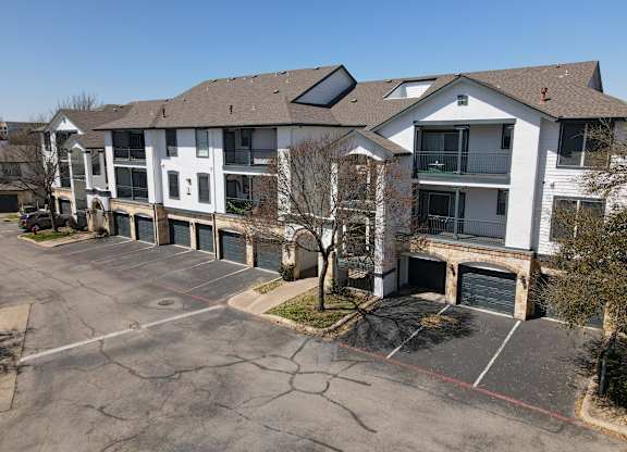 A large white building with a parking lot in front.