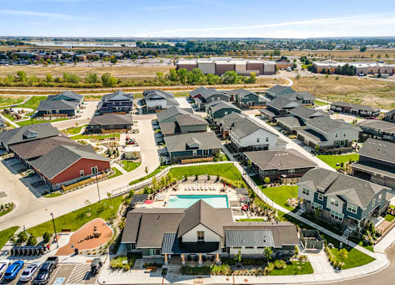 A large, modern housing complex with a swimming pool in the center.