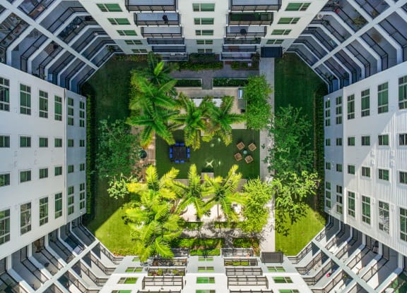 an aerial view of a courtyard in a building with trees and plants