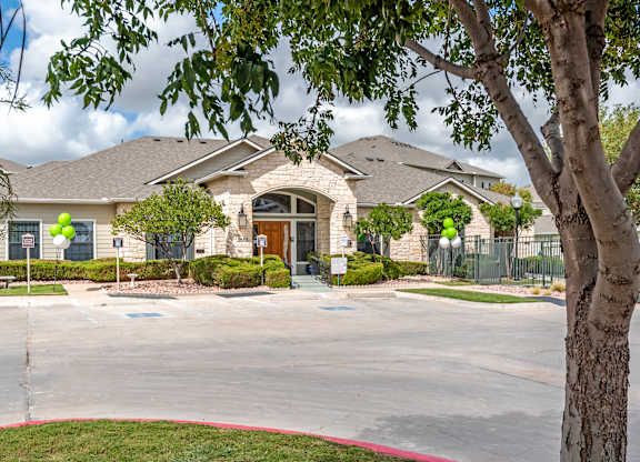 A large house with a tree in front.