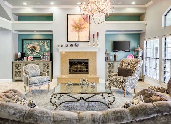 A living room with a fireplace and a chandelier.