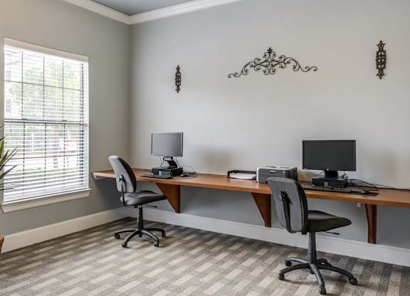 A room with a desk and two chairs.