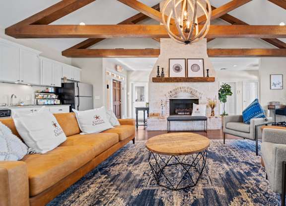 A living room with a fireplace and a large rug.