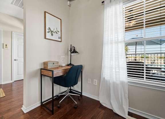 A room with a desk and chair in it.