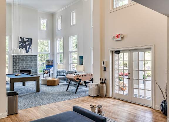 A living room with a pool table and a foosball table.