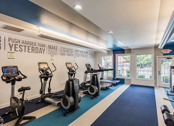 A gym with a row of stationary bikes and a sign that says