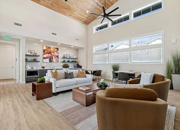 A living room with a white couch, brown armchair, and a coffee table.