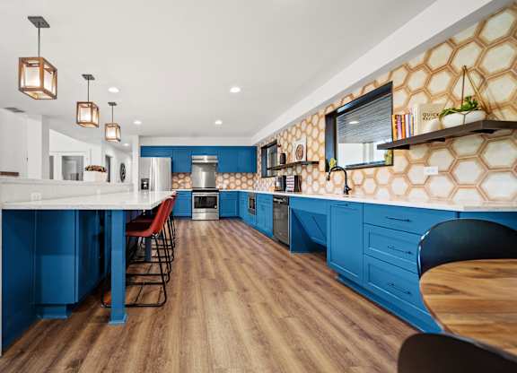 a kitchen with blue cabinets and white countertops