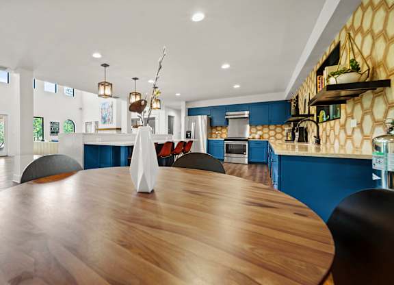 a large dining table with a view of the kitchen and living room