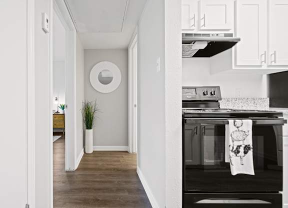 a kitchen in a 555 waverly unit with white cabinets and a black stove and oven