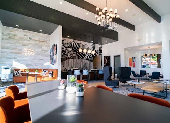 A modern dining room with a long table and chairs.