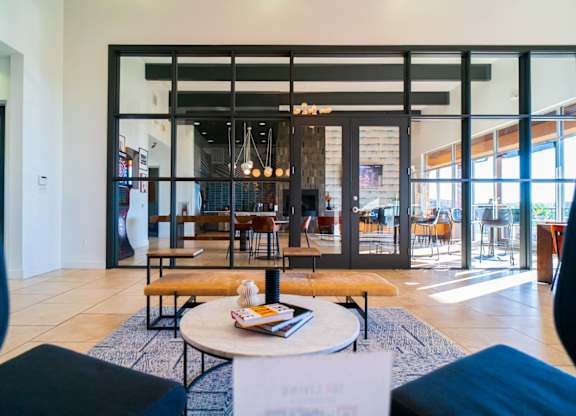 A modern living room with a glass door leading to a dining area.