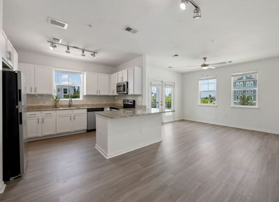a kitchen and living room with hardwood floors and white walls