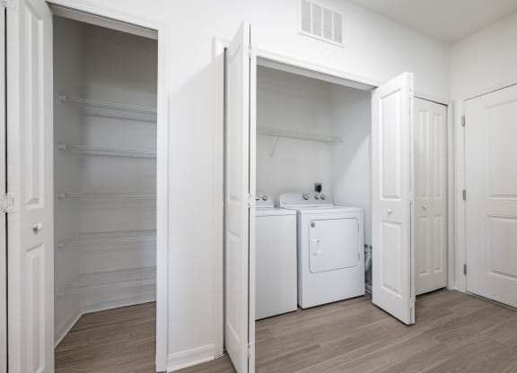 a bedroom with a washer and dryer and a closet with white doors