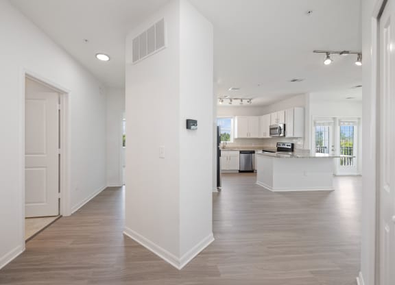 a bedroom with a medium sized bed and a kitchen with white cabinetry