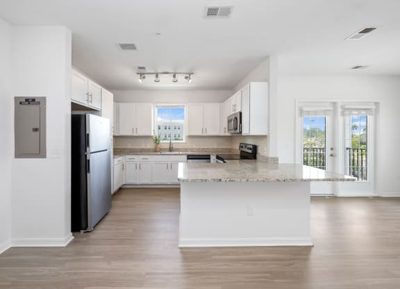 a kitchen with white cabinets and a large island with granite countertops