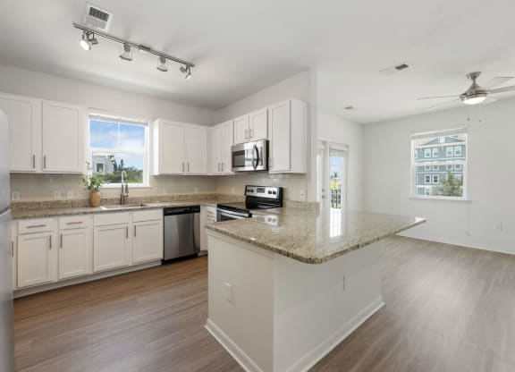 a kitchen with white cabinets and a granite counter top