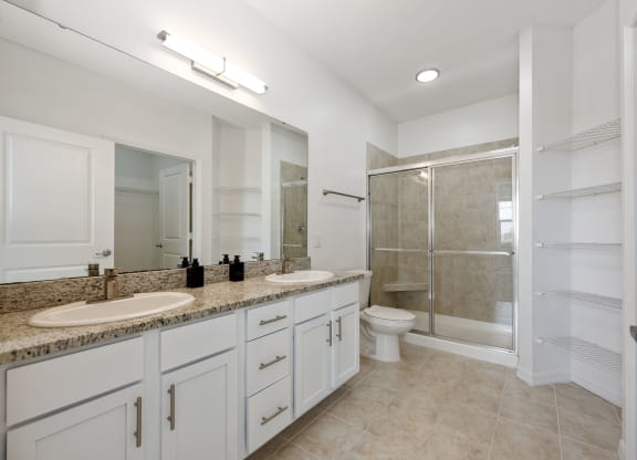 a bathroom with white cabinets and a granite countertop