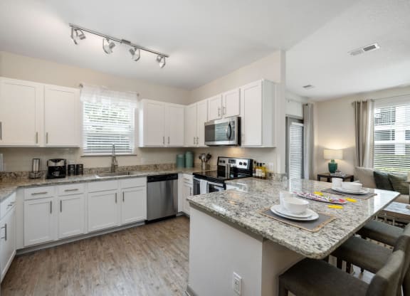 a kitchen with white cabinets and a granite counter top