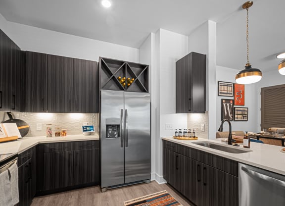 a kitchen with a stainless steel refrigerator and a sink