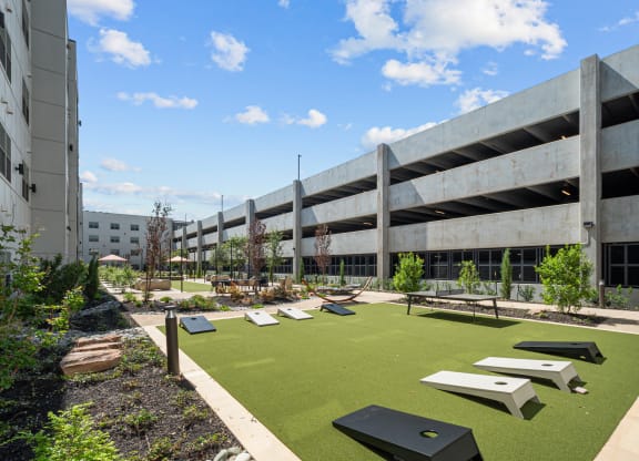 a courtyard with picnic tables and grass in front of an office building