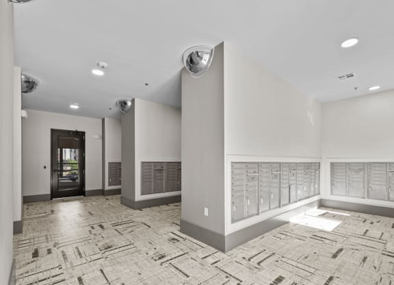 a large room with a wall of mailboxes and a door to a building