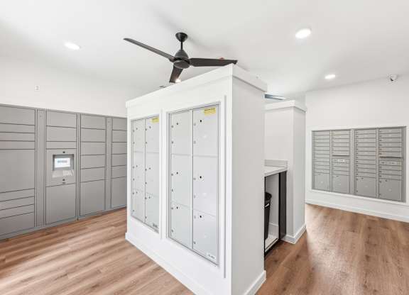 A room with a ceiling fan and a cabinet with drawers.