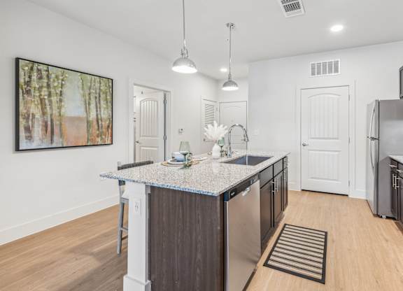 A kitchen with a granite countertop and stainless steel appliances.