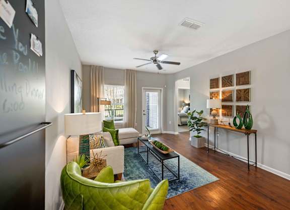 a living room with gray walls and a ceiling fan