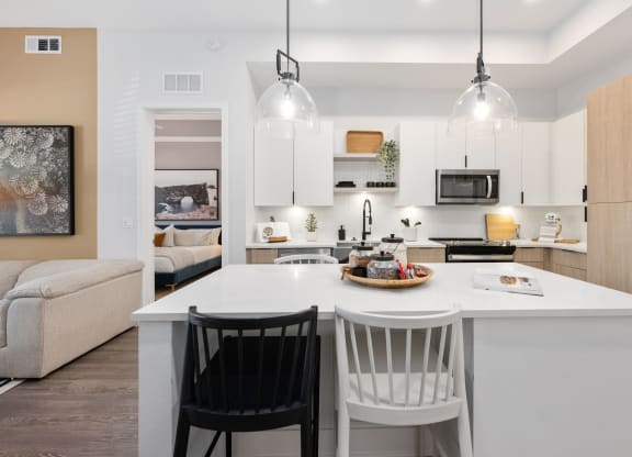 an open kitchen with a large island with two chairs