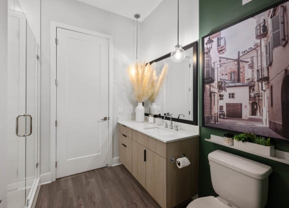 a bathroom with a toilet sink and mirror and a shower