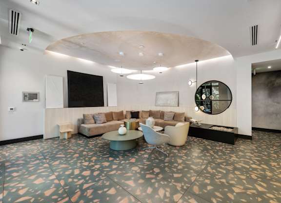 A modern living room with a large circular table and a couch.