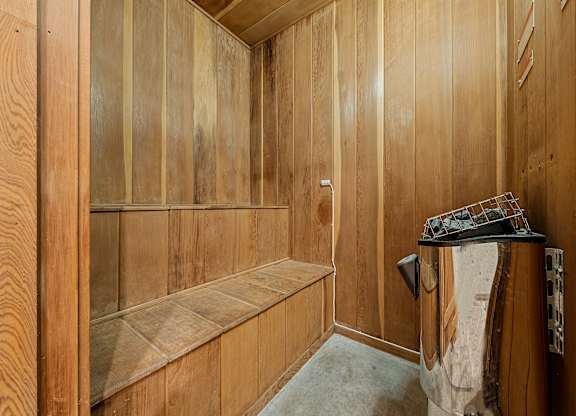 a wood paneled bathroom with a shower and a sink