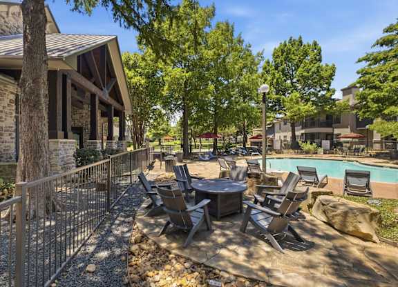 A backyard with a pool and patio furniture.
