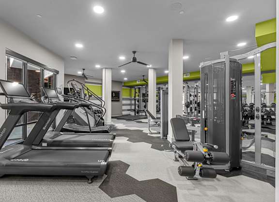 A gym with treadmills, weights, and other exercise equipment.