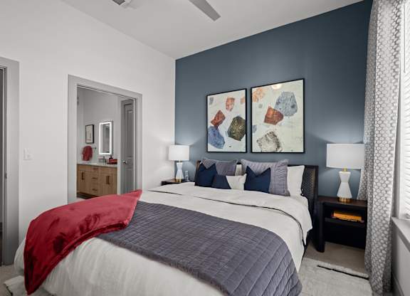 A bedroom with a bed, nightstands, and a painting on the wall.