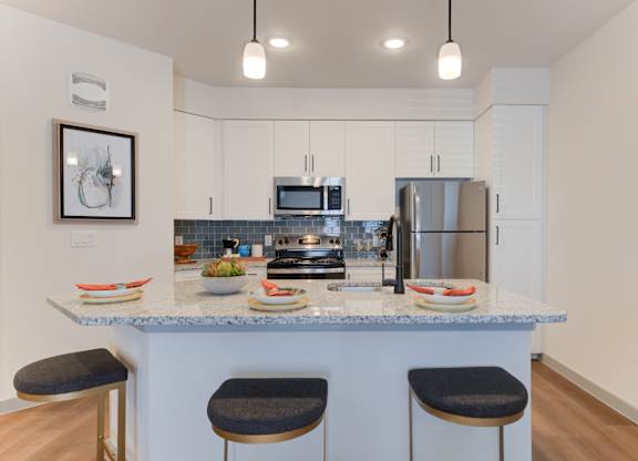 a kitchen with a granite counter top with three stools