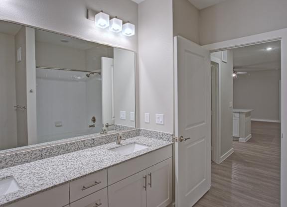 A bathroom with a vanity and a large mirror.