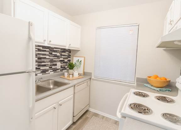 A kitchen with white appliances and cabinets.