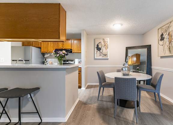 A kitchen with a table and chairs in the foreground.