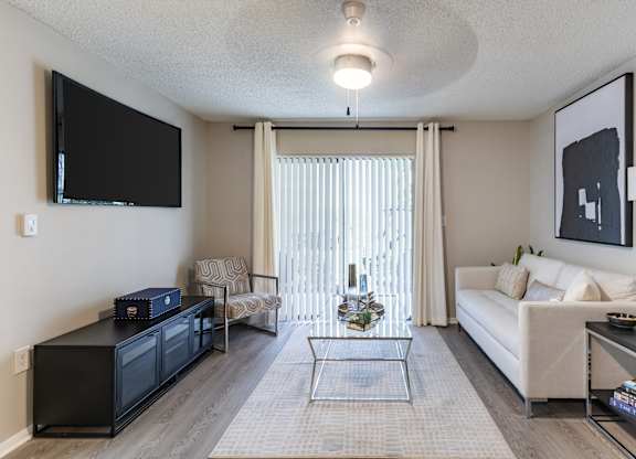 A living room with a black television and a white couch.