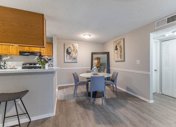 A dining room with a table and chairs.