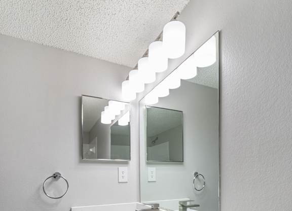 A white sink vanity with a mirror above it.