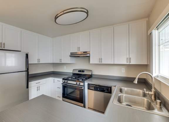 A kitchen with white cabinets and stainless steel appliances.