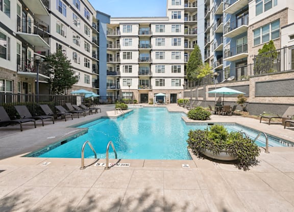 A large swimming pool in the middle of a courtyard surrounded by buildings.
