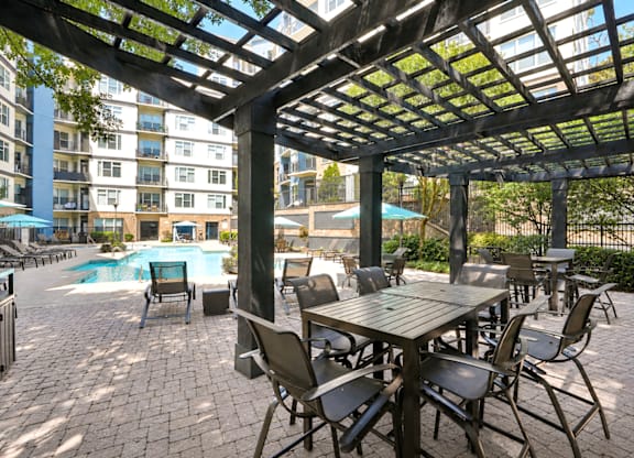 A patio with a table and chairs under a pergola.