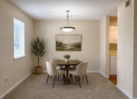 A dining room with a table and chairs.