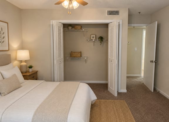 A bedroom with a large bed and a small closet.