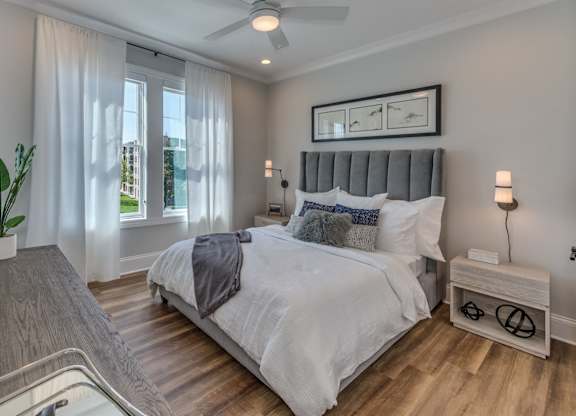 A bedroom with a large bed and a ceiling fan.