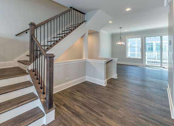 A modern builder grade staircase leading to the second floor with bedrooms and a first floor nook in the living room for a desk.